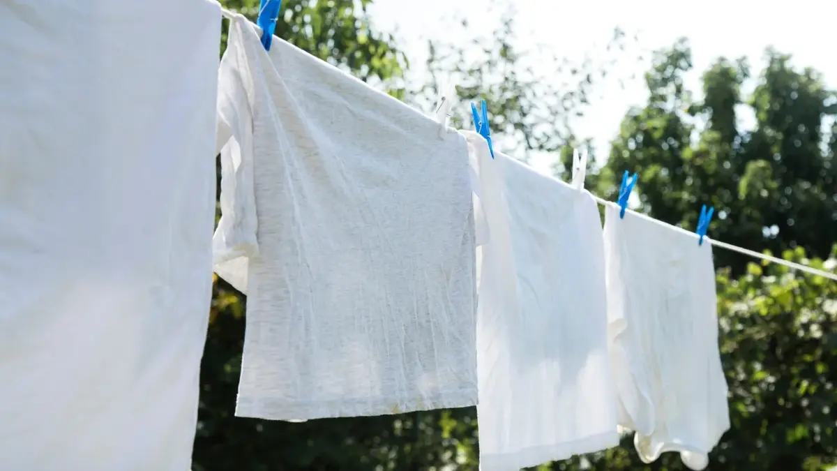 Białe pranie suszy się na sznurze, na zewnątrz. 