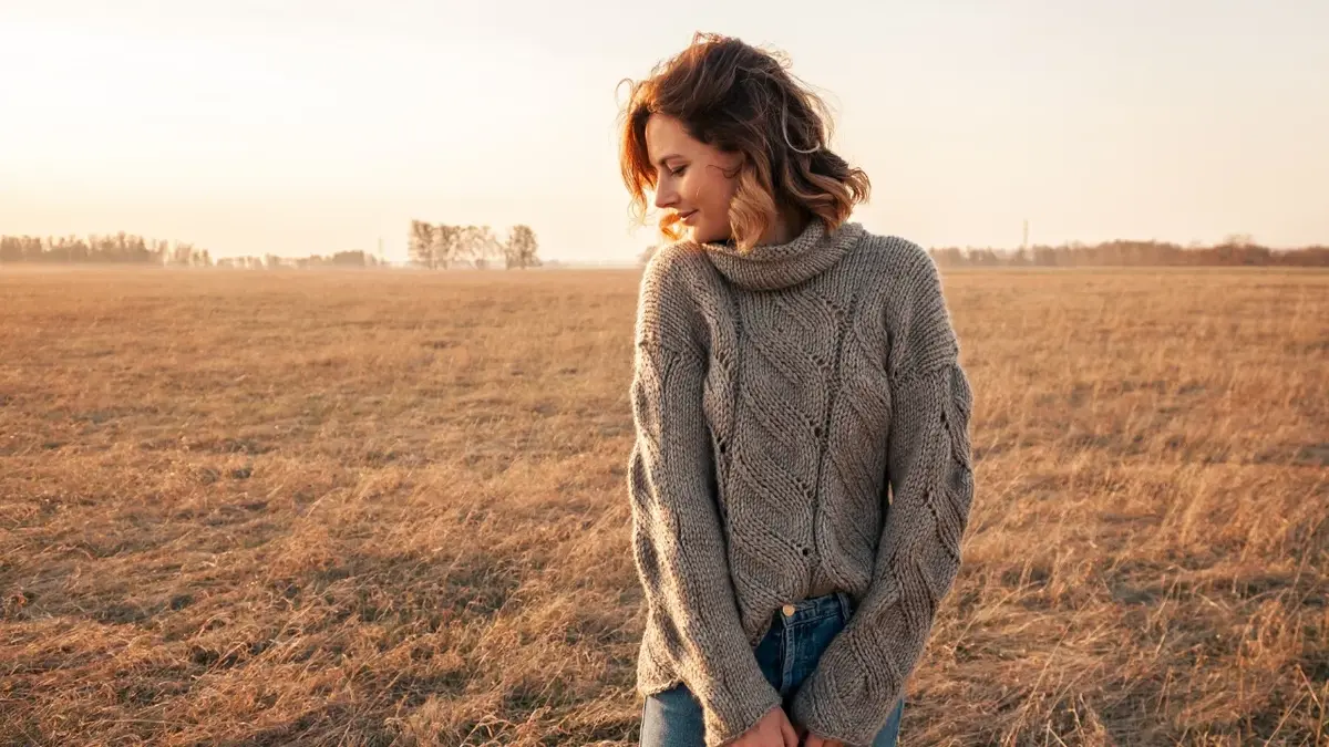 dziewczyna na tle pola w szarym swetrze