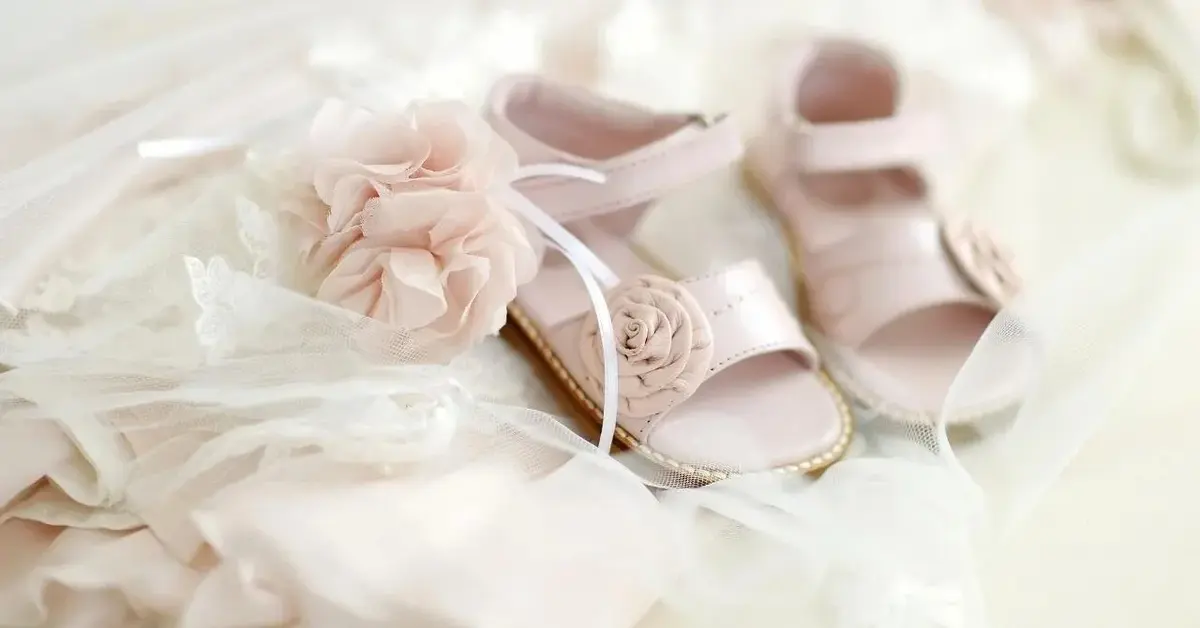 Śliczne ubranka i buciki naszykowane jako prezent na chrzest.