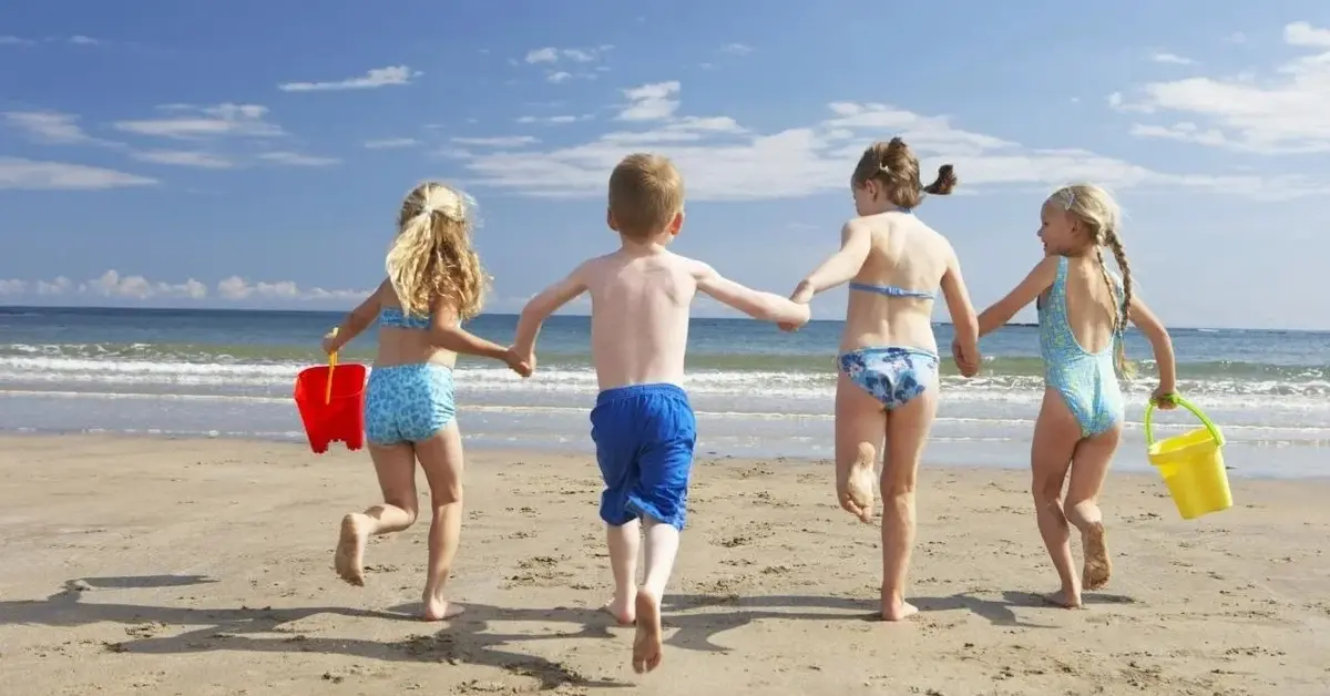 Dzieci są na wakacjach. Biegają po plaży.