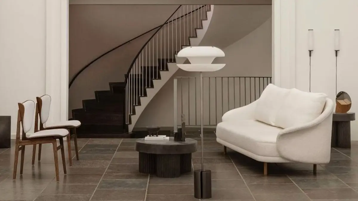 Salon w stylu organicznym z białą sofą, dwoma krzesłami, czarnym okrągłym stolikiem