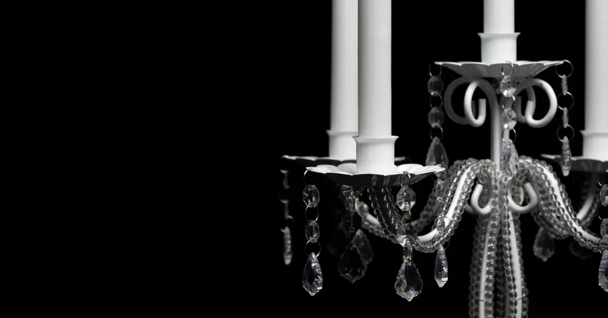 Wysokie świeczniki metalowe eleganckie z białymi świecami na czarnym tle