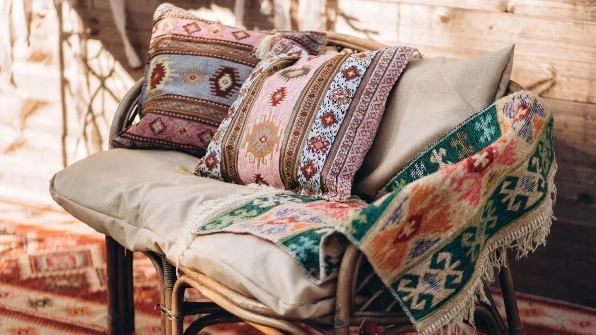 Wzorzyste poduszki i dywanik na szarej sofie
