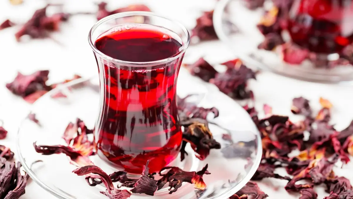 herbata z hibiskusa w szklanej filiżance na białym tle 
