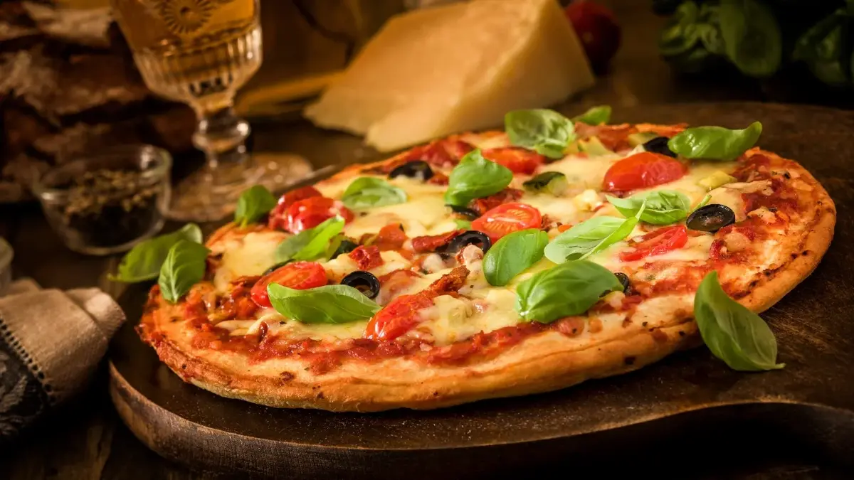 Pizza z serem, pepperoni i oliwkami na podkładzie drewnianym do podawania pizzy