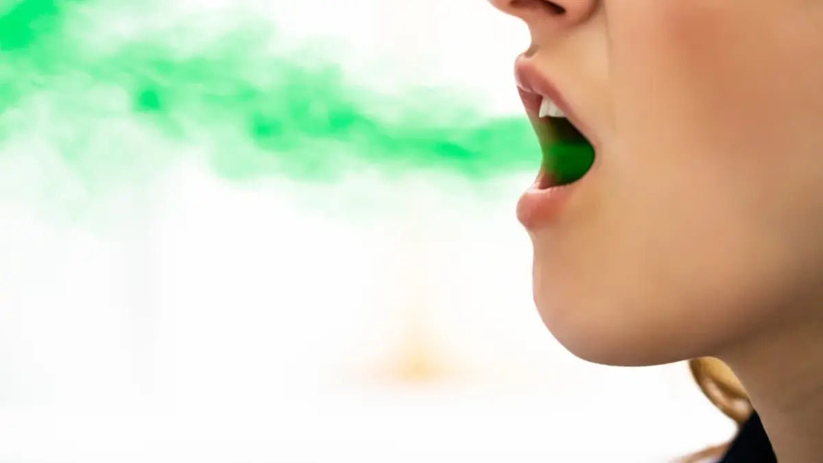 Profil kobiety z nałożona grafiką zielonego dymu lecącego z ust