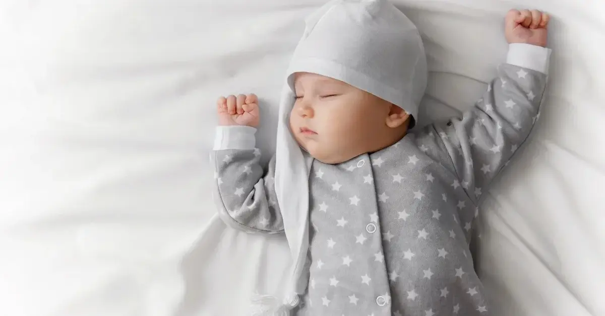 Śpiące niemowle w czapeczce i piżamce