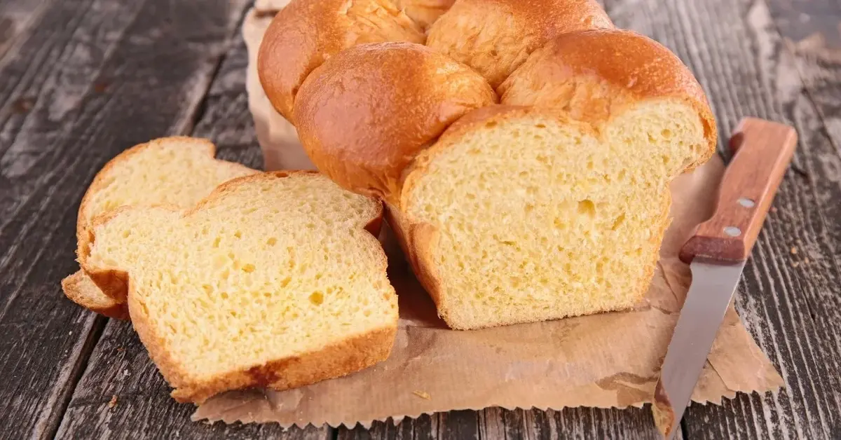 Ciasto drożdżowe z formy, obok ukrojony dwa  kawałki . Po drugiej stronie leży nóż.