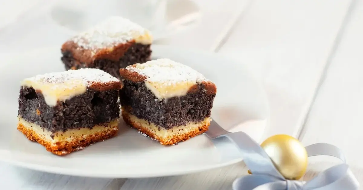 Trzy kawałki makowca na białym talerzyku i białym tle