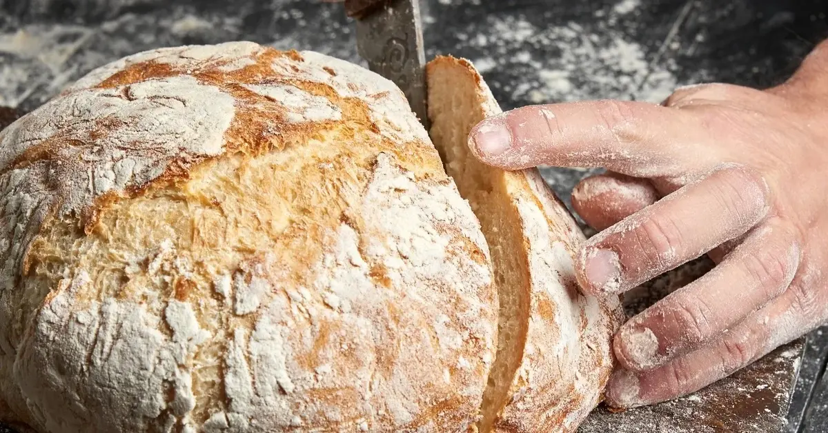 Świeży bochenek chleba z odkrawaną piętką
