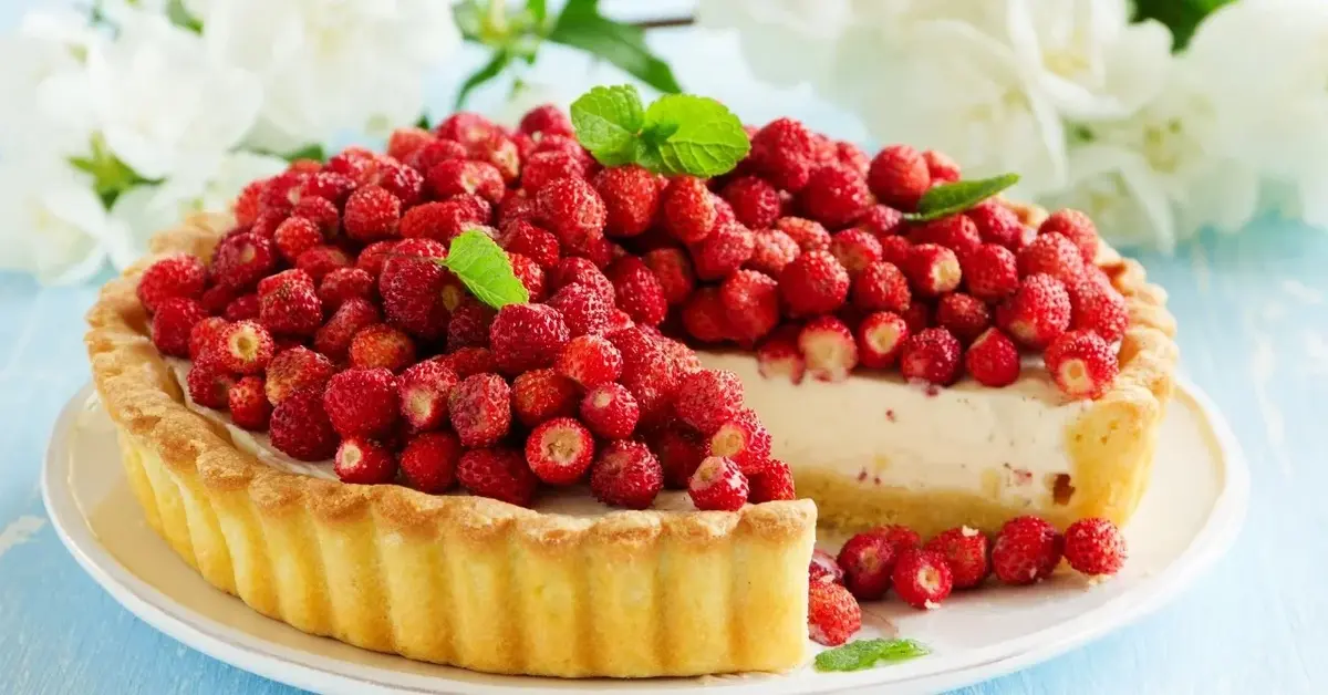 Tarta z mascarpone i dużą ilością poziomek na wierzchu