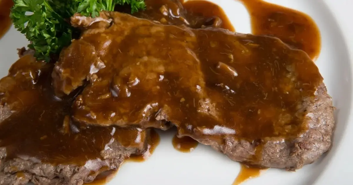 Sos pieczeniowy na kawałkach pieczeni na talerzu