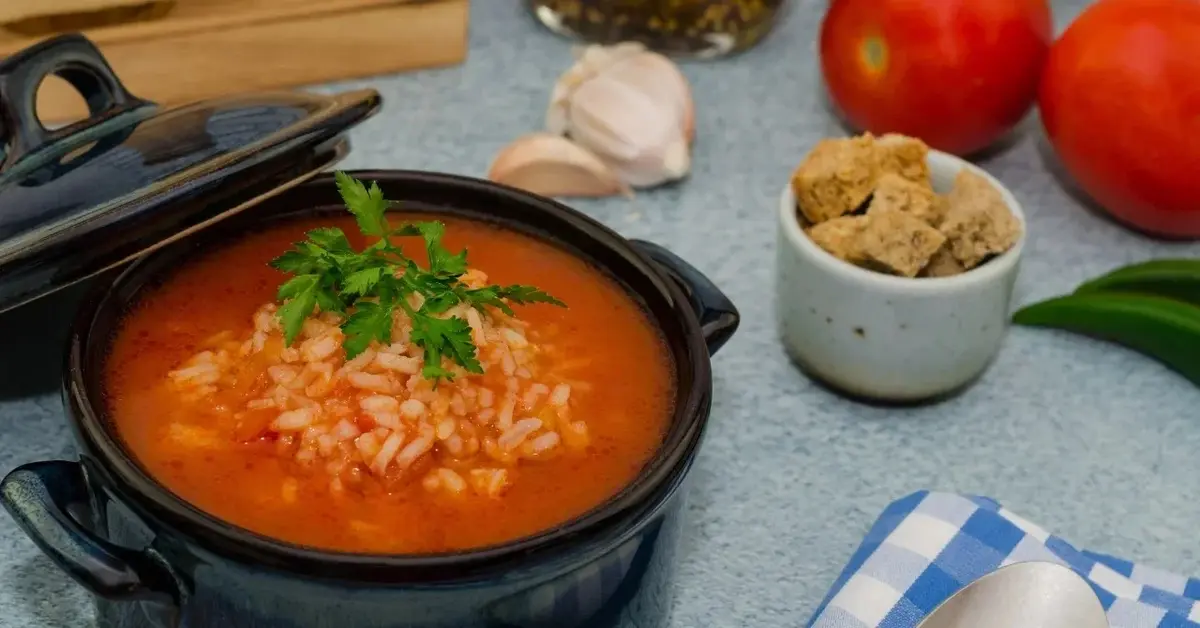 Zupa pomidorowa z ryżem w czarnym garnku 