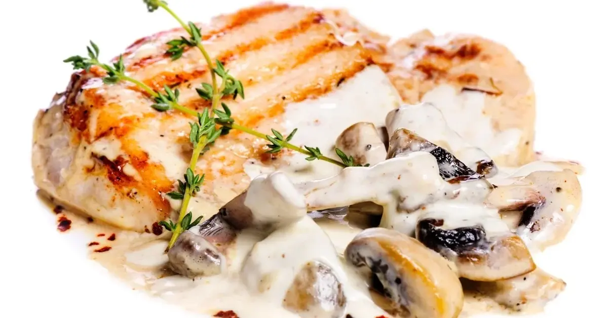 Karkówka z pieczarkami w sosie własnym na białym talerzu