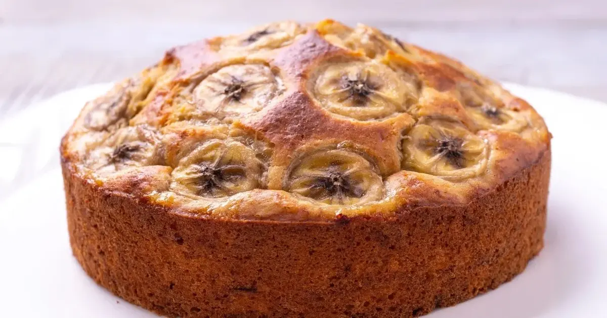 Bananowiec udekorowany plasterkami banana na białym talerzu