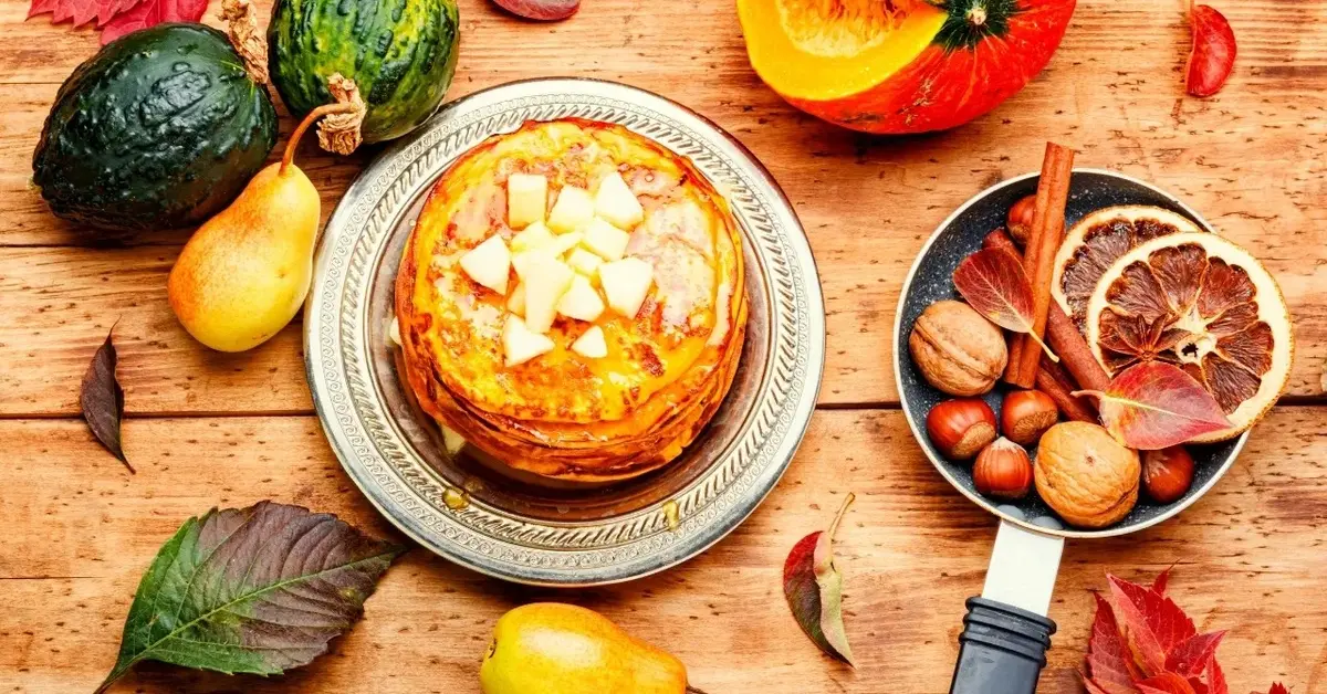 Placki z dyni na talerzu, dookoła dynie, gruszki i owoce