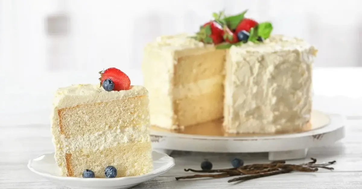 Tort z kremem mascarpone, obok talerzyk z nałożonym kawałkiem tortu