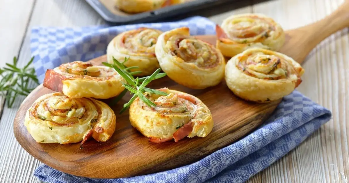 Przekąski z ciasta francuskiego z serem i szynką zawinięte w ślimaczki