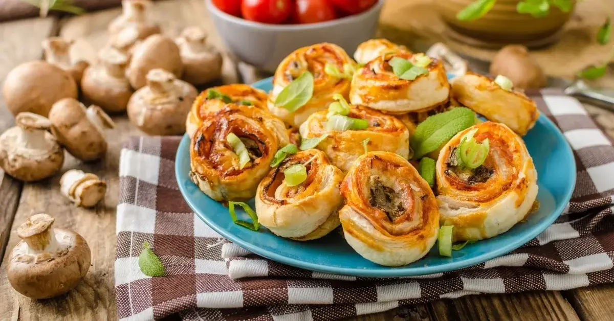 Przekąski z ciasta francuskiego z serem i szynką zawinięte w ślimaczki