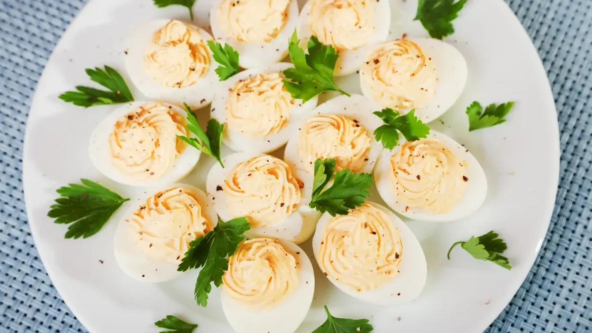 Jajka faszerowane na liściu sałaty na białym ozdobnym talerzu