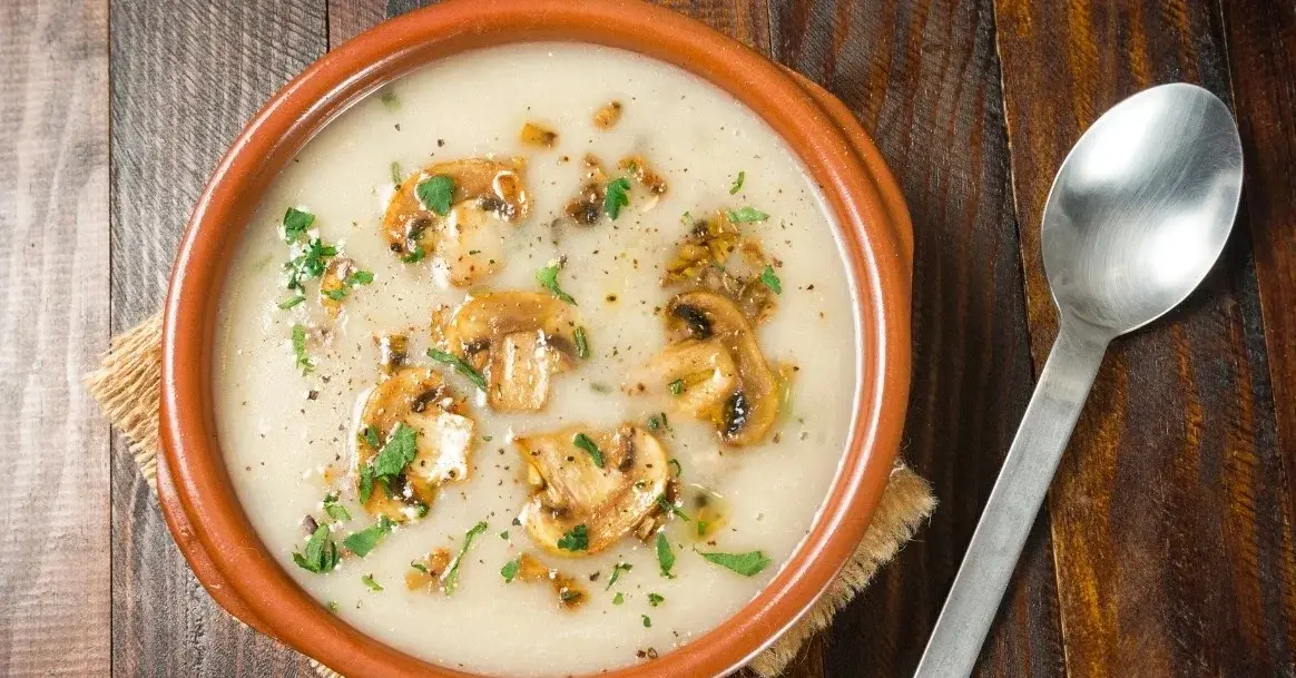 Zupa pieczarkowa z makaronem w brązowej miseczce