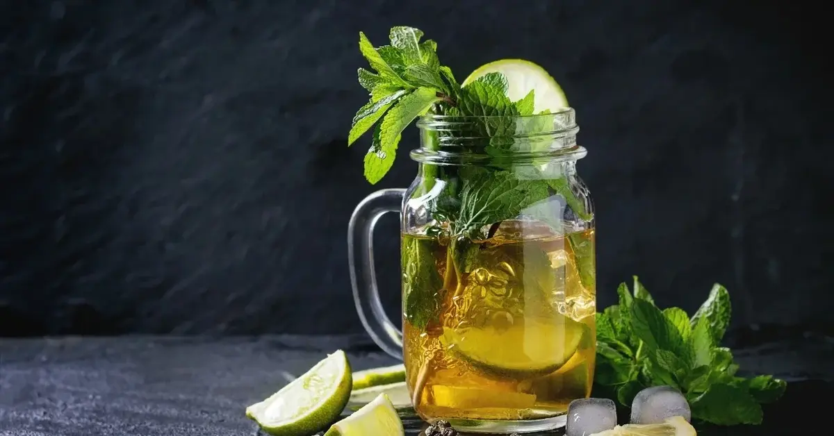 Zielona herbata z ogórkiem w szklance z uszkiem