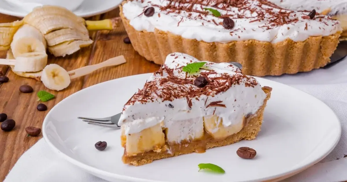 Porcja Banoffee pie na talerzyku, w tle reszta ciasta