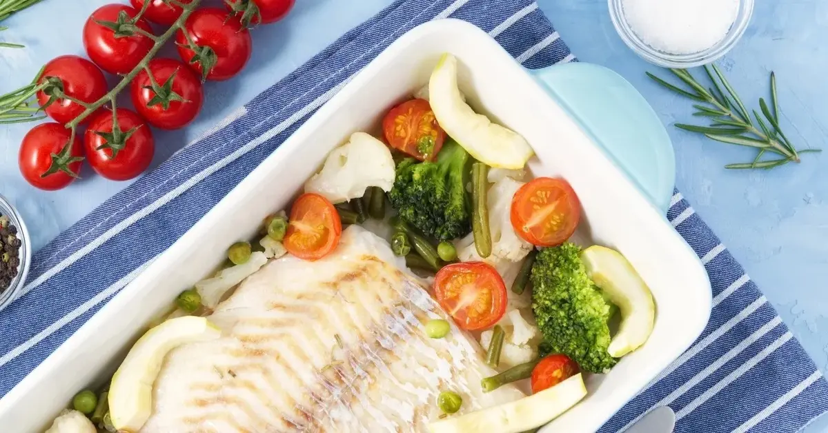 Dorsz z piekarnika z warzywami w naczyniu do zapiekania