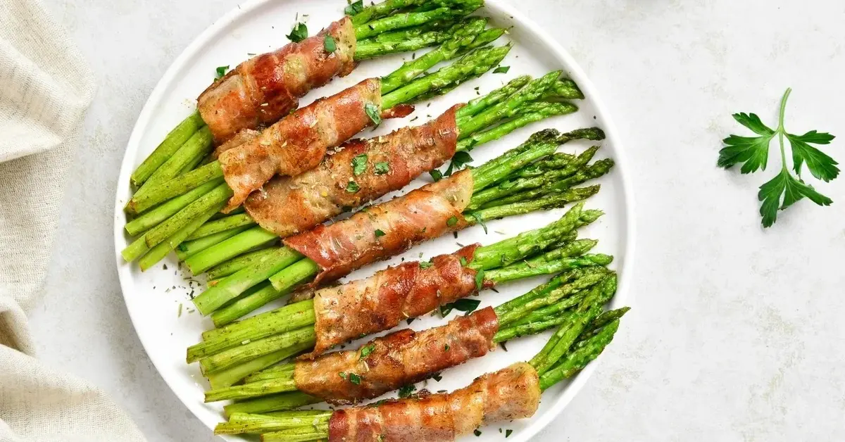 szparagi w boczku na białym talerzu