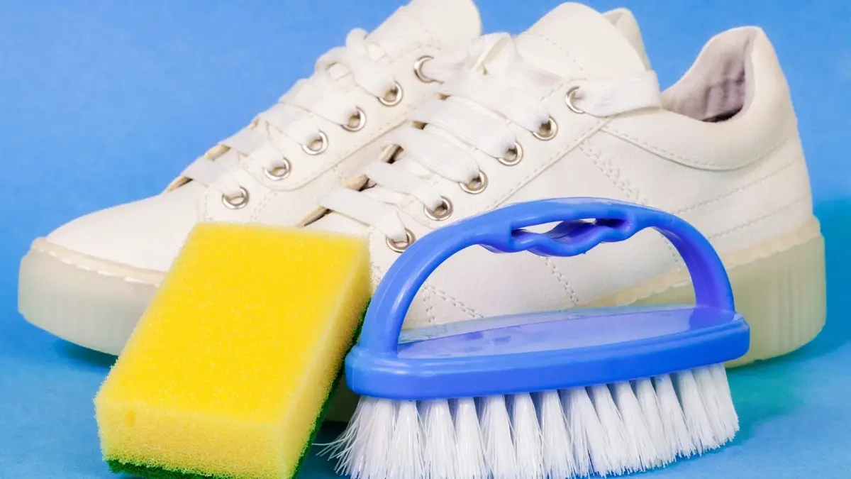 Białe buty i przyboru do czyszczenia: ściereczka i szczotka