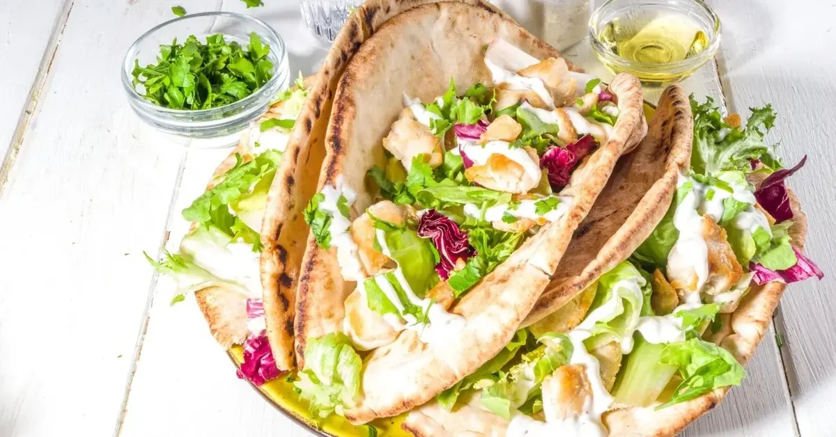 Sałatka gyros z sałatą, pomidorami, ogórkami i mięsem z kurczaka na chlebku pita