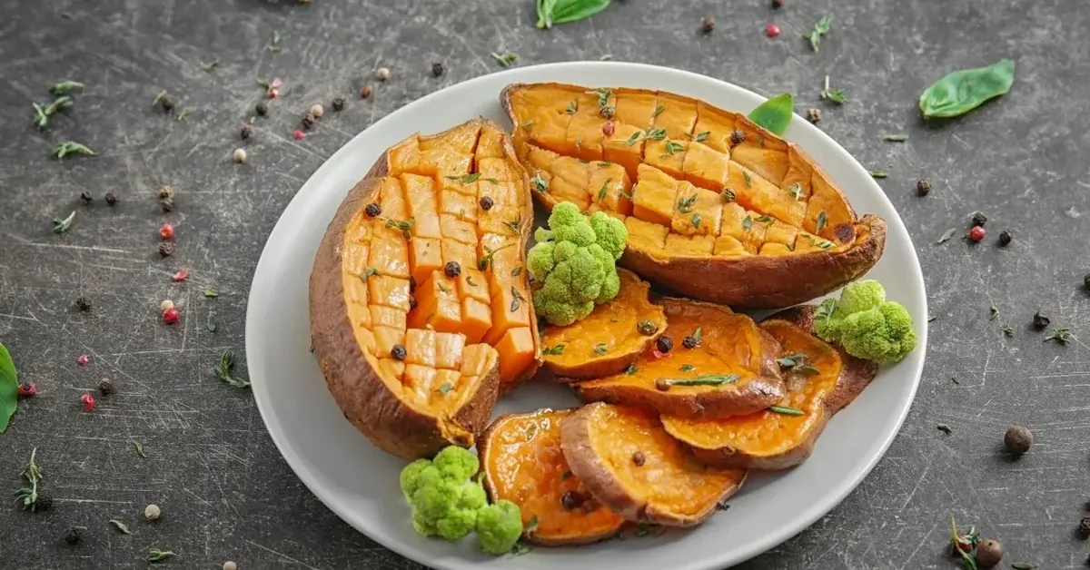 Pieczone bataty przekrojone na pół na białym talerzu