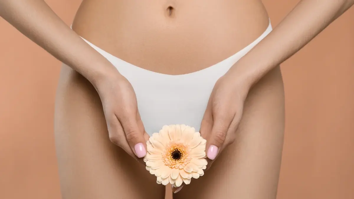 Majtki menstruacyjne na kobiecie trzymającej kwiatek 