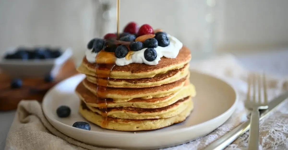 Placuszki z mascarpone i owocami na bialym talerzu