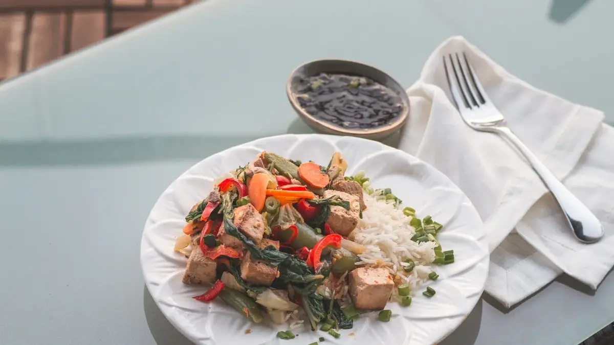 Tofu z warzywami i ryżem na talerzu 