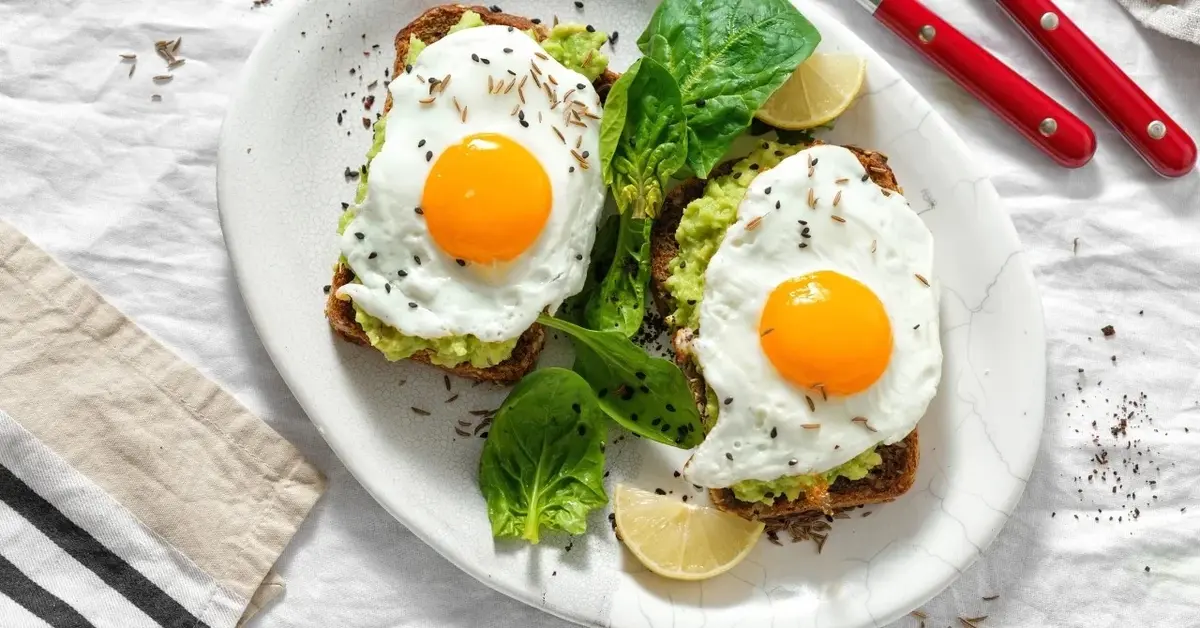 Tosty z awokado i jajkiem sadzonym na talerzu