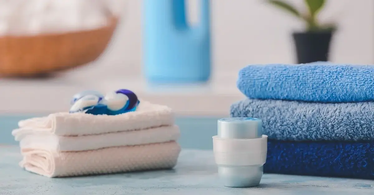 Złożone pranie a na nim kapsułka do prania