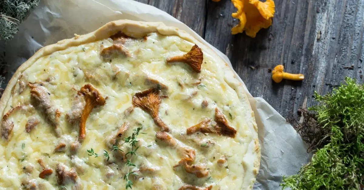 Quiche z kurkami obok świeże kurki