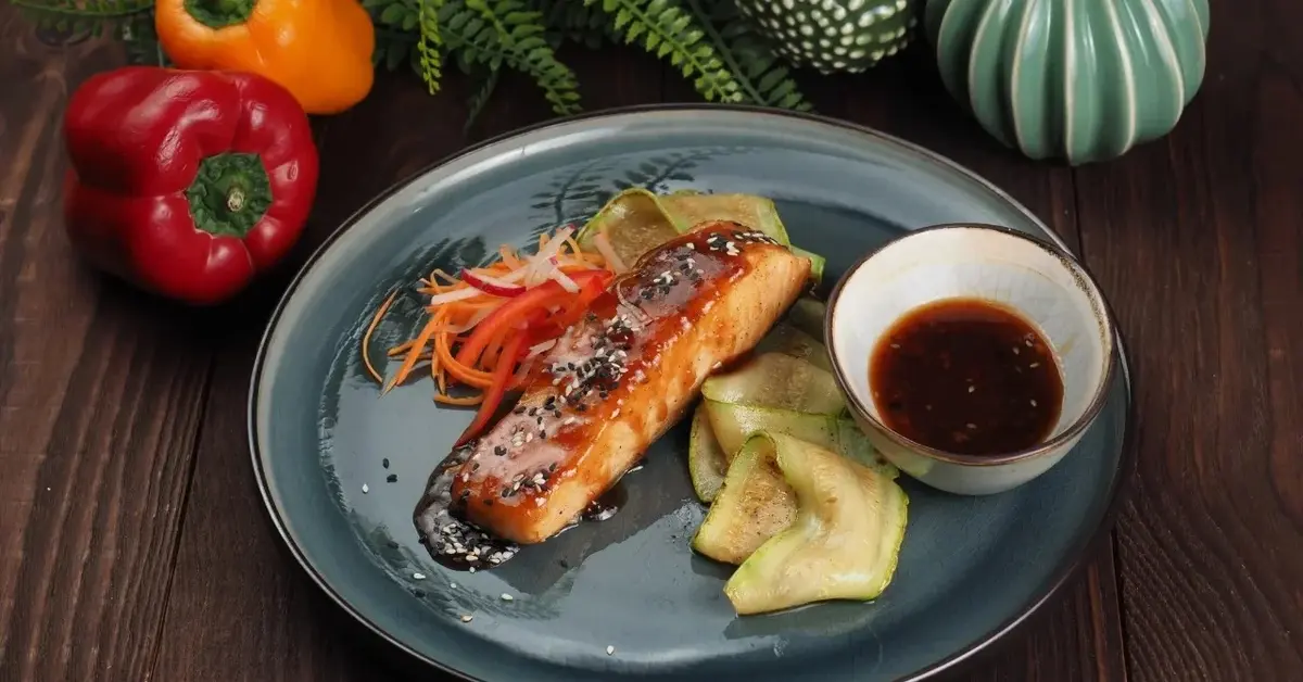 Łosoś w sosie teriyaki z sosem w miseczce i warzywami