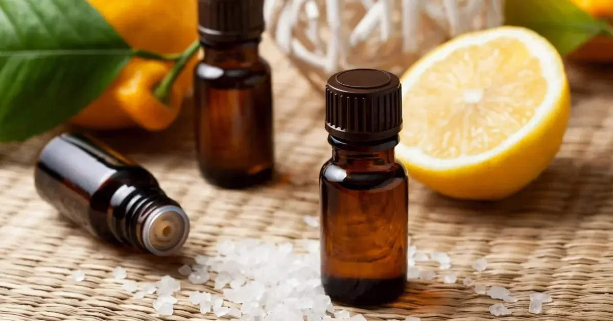 Olejek cytrynowy w buteleczkach, obok świeże cytryny