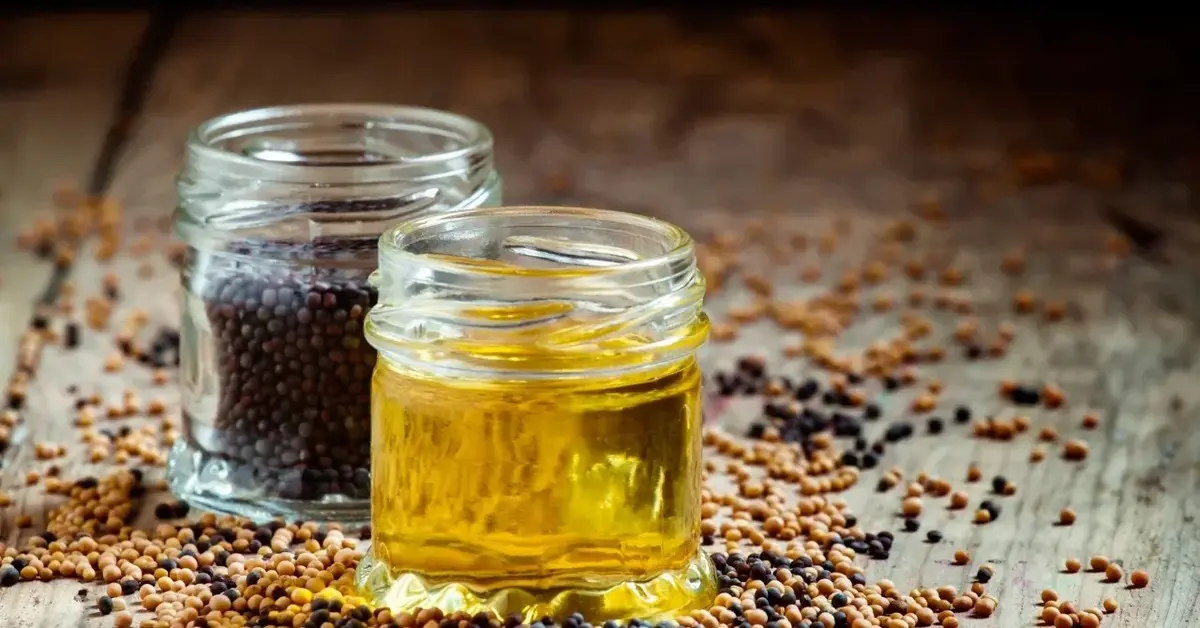 Olej z czarnuszki w słoiczku, obok słoiczek z nasionami czarnuszki