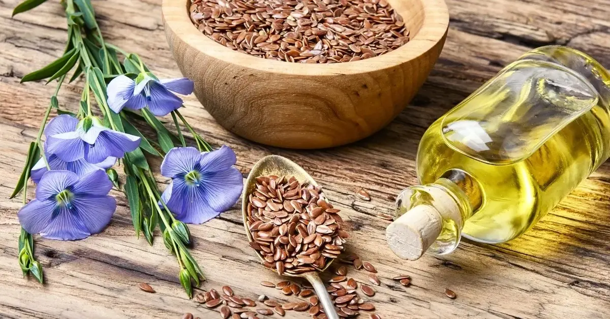 Olej lniany w buteleczce, obok miseczka z lnem