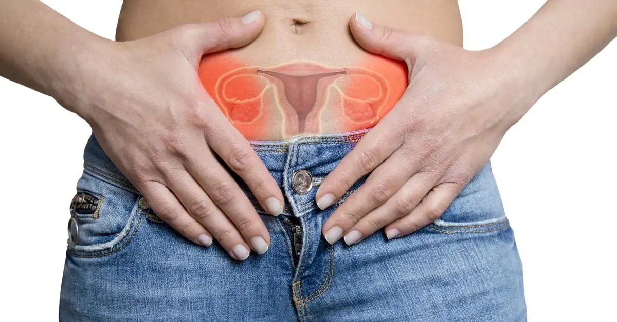 Kobieta trzymająca ręce na brzuchy na który nałożona jest grafika przedstawiająca jajniki