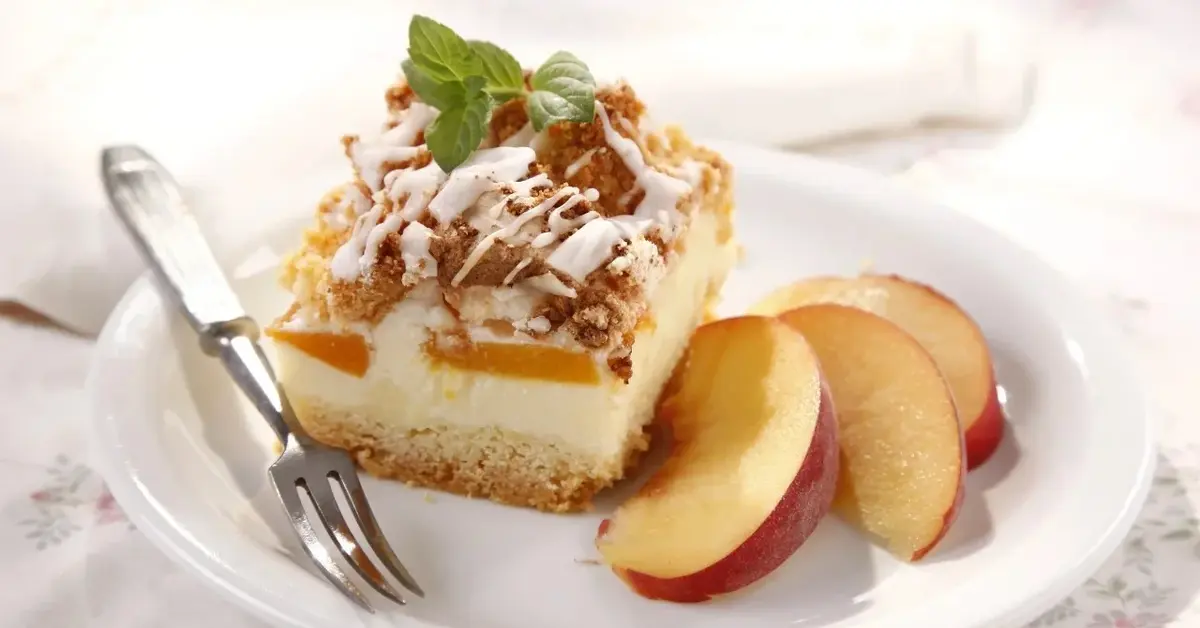 Sernik z brzoskwiniami na białym talerzyku