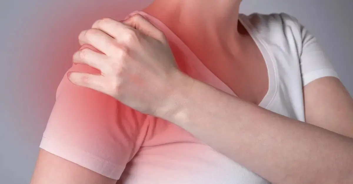 Kobieta trzymająca się za bark