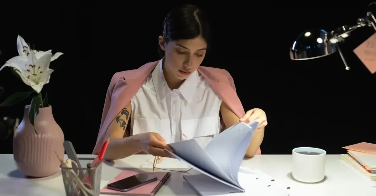 Kobieta przeglądająca dokumenty przy biurku 