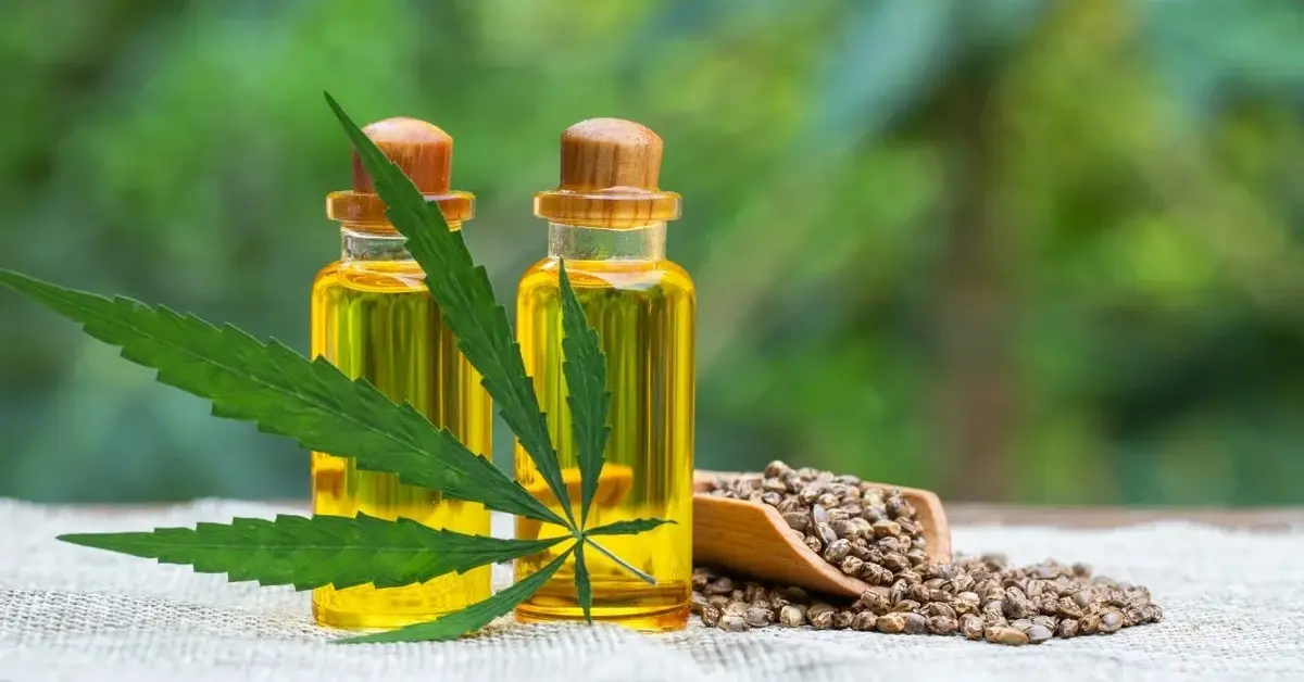 Olej konopny w buteleczkach, obok liść konopii