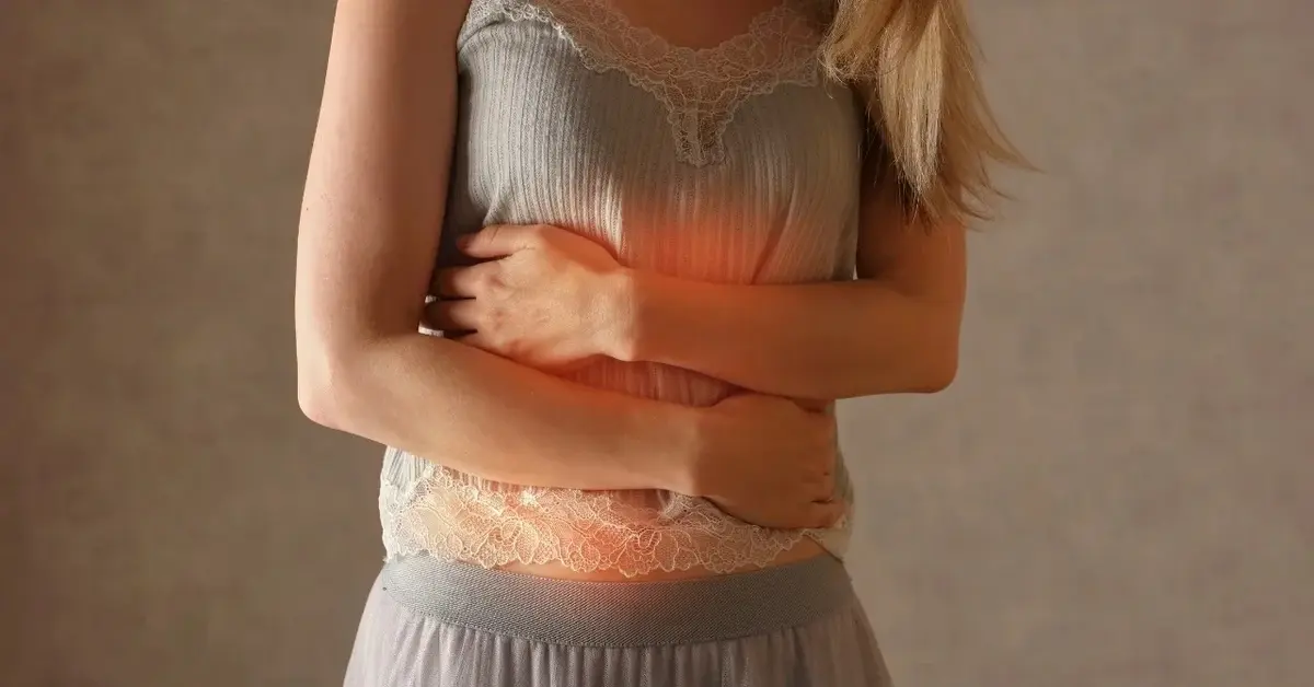 Kobieta trzymająca się za brzuch