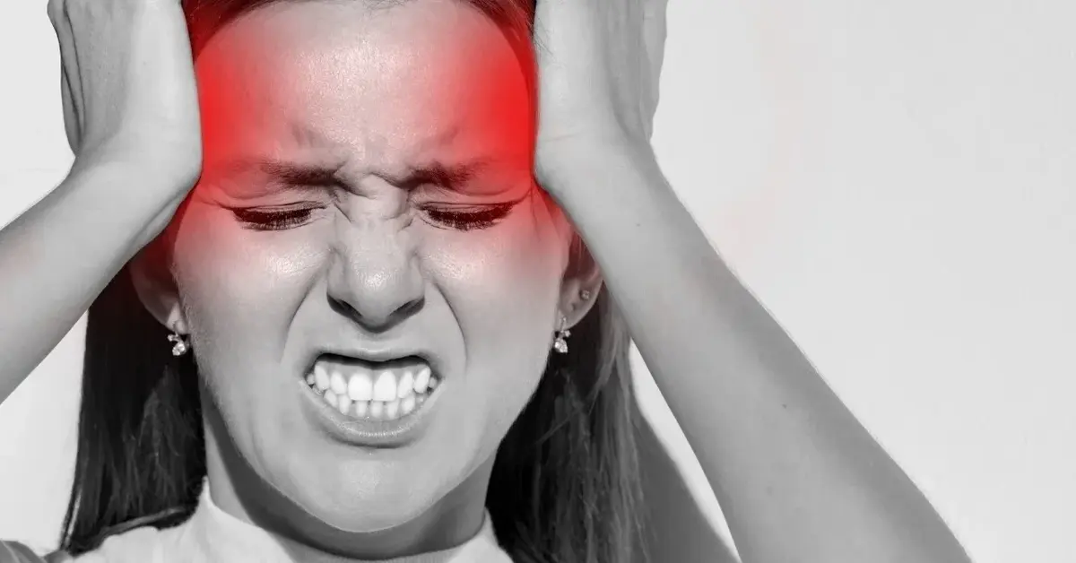 Kobieta trzymając się za skronie