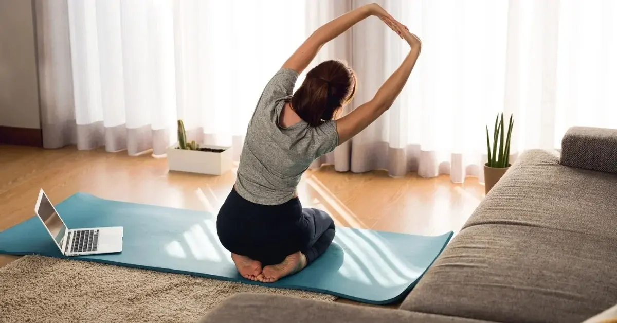 Kobieta rozciągająca plecy na macie w pokoju